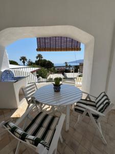 a table and chairs on a patio with a view of the ocean at Il Portico sul mare in Santa Marina Salina