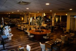 a dining room with tables and chairs and a restaurant at Budget Hostel De Elderschans in Aardenburg