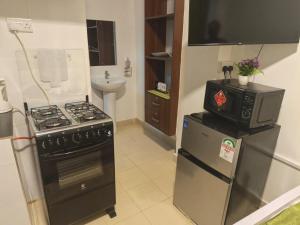 a kitchen with a stove and a refrigerator at Gweth Haven Homes in Nakuru