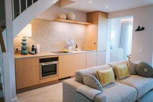a living room with a couch and a kitchen at Sünn un See - Weststrand-Blick mit Sauna in Ahrenshoop