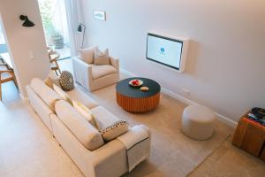 a living room with a couch and a table and a tv at Sünn un See - Weststrand-Blick mit Sauna in Ahrenshoop