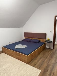 a bedroom with a large bed with a blue blanket at Villa Loni in Pozharan