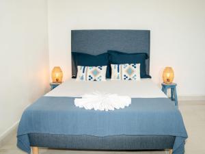 a bedroom with a bed with a blue blanket and two lamps at Charmant T1 - Vue Mer in Pointe-à-Pitre