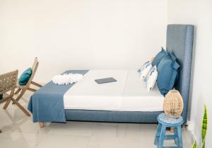 a bedroom with a bed and a blue chair at Charmant T1 - Vue Mer in Pointe-à-Pitre +3 photos