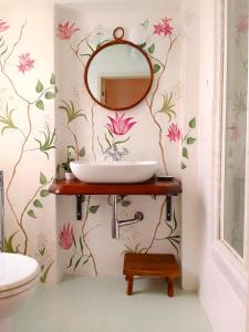 a bathroom with a sink and flowers on the wall at Villa Remignoli in San Gimignano +40 photos