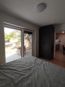 a bedroom with a bed and a sliding glass door at Apartma Pod Hrastom in Koper