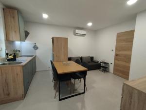 a kitchen and living room with a table and a couch at Apartma Pod Hrastom in Koper