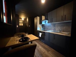 a kitchen with a table and a sink and cabinets at L'Atelier des Amoureux studio à 2 pas du château in Sedan +10 photos
