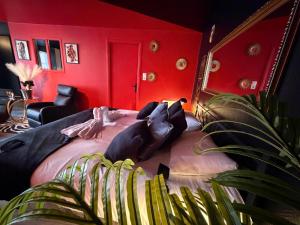 a bedroom with a large bed with red walls at L'Atelier des Amoureux studio à 2 pas du château in Sedan