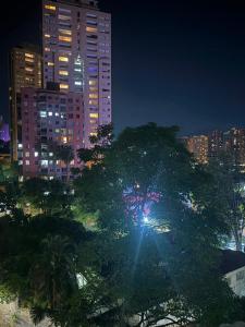 a tree in front of a city at night at We Rent VIP - San Julián in Medellín