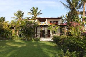 a house with a lawn in front of it at Pousada Barra do Mundaú in Lavagem
