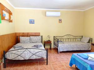 a bedroom with two beds and a table at ΓΑΛΗΝΗ 2 in Litochoro