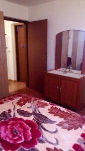 a room with a bathroom with a mirror and a flower on the floor at Apartment Bruna in Bužinija
