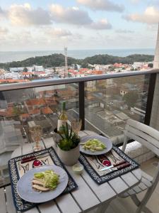a table with two plates of food on a balcony at STUDIO Mar azul 1206 in São Luís