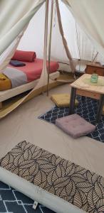 a room with two beds and a table in a tent at Ferme équestre de la Molière in Naves