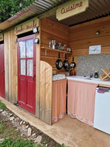 a kitchen with a red door and a stove at Ferme équestre de la Molière in Naves