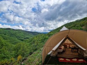 a tent in the middle of a green valley at Ferme équestre de la Molière in Naves +7 photos