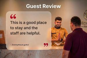 a man standing next to a sign that says guest review at Townhouse Krishnagiri Formerly Vijay Inn in Krishnagiri +47 photos