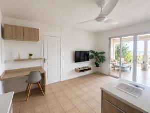 a kitchen and living room with a tv and a couch at Between Caribean Seas in Cul de Sac