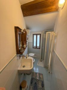 a small bathroom with a sink and a mirror at La curva del Serpente in Abbadia San Salvatore +6 photos