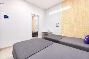 a bedroom with two beds and a brick wall at Monggo Mampir Tanjung Duren By Reccoma in Jakarta