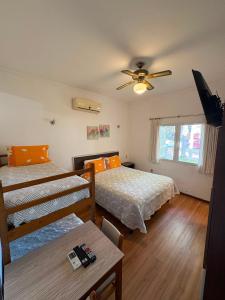 a bedroom with two beds and a table and a ceiling fan at Hotel Argentina in Atlántida +75 photos