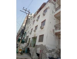 an old white building with windows and a street at Hotel Viren Sofitel, Agra in Agra