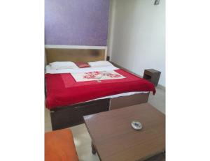 a small bedroom with a bed and a table at Hotel Viren Sofitel, Agra in Agra +3 photos