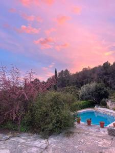 a swimming pool in a garden with a sunset at Drago Luxury Villa in Tarragona