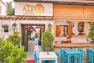an outdoor restaurant with blue tables and chairs at Alayaz Hotel in Alaçatı