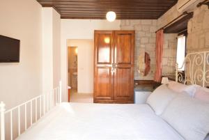 a bedroom with a white bed and a wooden cabinet at Alayaz Hotel in Alaçatı