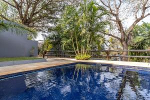 a swimming pool in the backyard of a house with trees at Ndumu Safari Resorts in Jozini