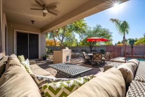 a patio with a couch and an umbrella at Movie Theater Pool Arcade Fire Pit in Glendale