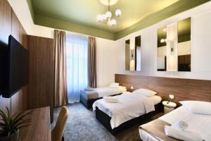 a hotel room with two beds and a table at BOUL ROSU RESIDENCE free private parking in Arad