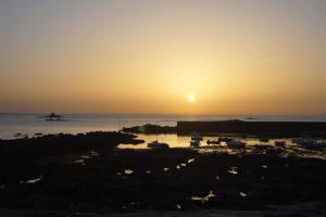 a sunset over the ocean with boats in the water at Ty Le Gall in Plouescat
