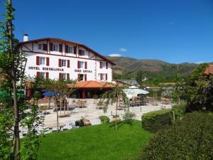 a large white building with a courtyard in front at Hotel Eskualduna Chez Katina in Saint-Martin-dʼArrossa