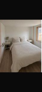 a bedroom with a large white bed and a window at Krowji in Gulval
