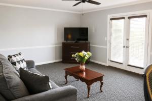 a living room with a couch and a table with flowers at Beau Rivage Golf and Resort in Myrtle Grove