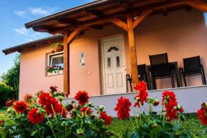 a house with red flowers in front of it at Викендица Братунац in Bratunac
