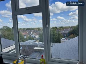 a kitchen window with a view of a roof at New Top Floor Studio Sleeps 3 Very Spacious in Finchley