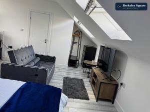 a bedroom with a couch and a tv and a table at New Top Floor Studio Sleeps 3 Very Spacious in Finchley