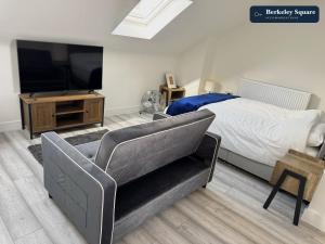 a bedroom with a bed and a tv and a chair at New Top Floor Studio Sleeps 3 Very Spacious in Finchley