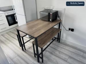 a wooden table with a microwave on it in a kitchen at New Top Floor Studio Sleeps 3 Very Spacious in Finchley