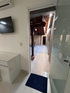 a hallway leading to a dining room with a glass door at Flamboyant Stay Rooms in Goiânia