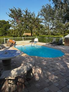 a small swimming pool with a table and chairs at La Cigalière 2 charmant T2 avec terrasse dans villa in Solliès-Ville