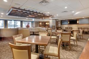 a restaurant with tables and chairs in a room at Best Western PLUS Port O'Call Hotel in Calgary