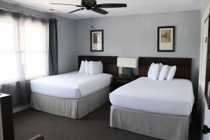 a hotel room with two beds and a ceiling fan at Beau Rivage Golf and Resort in Myrtle Grove