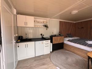 a small kitchen with a bed and white cabinets at Srbská Kamenice 22 in Srbská Kamenice
