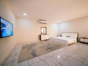a bedroom with a bed and a tv on a wall at Desert Dune Farmhouse - By Seven Elements in Ras al Khaimah +43 photos