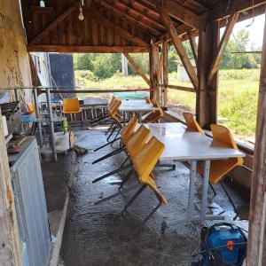 a group of tables and chairs in a building at Halte à Ecluse d'Hôte in Calonges